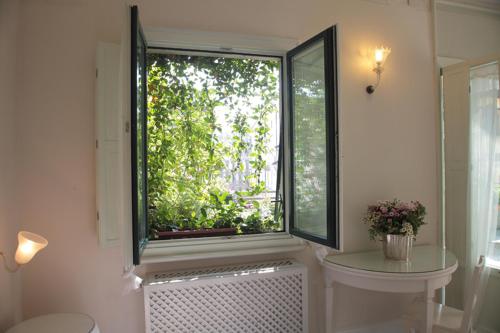 a bathroom with a window with a toilet and a sink at Milano Suites in Milan