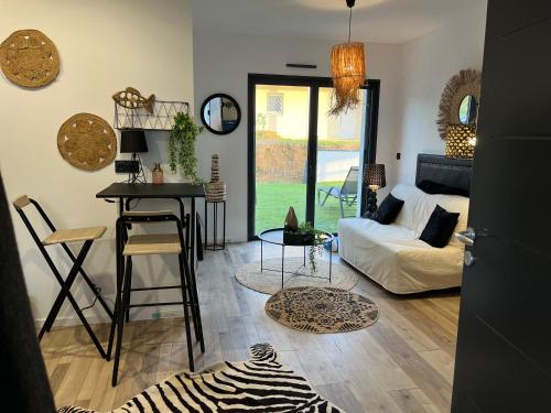 un salon avec un canapé blanc et une table dans l'établissement studio Lauralex, à Montardon