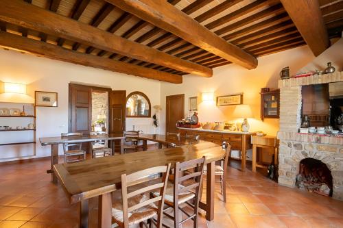 uma sala de estar com mesas de madeira e uma lareira de pedra em Agriturismo Fattoria di Statiano em Pomarance