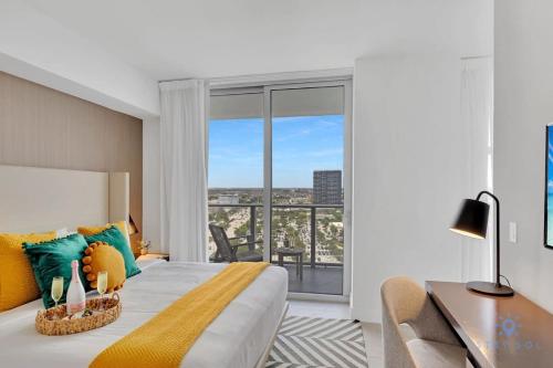 a bedroom with a bed and a desk and a window at Bayview Luxury, 3BR Condo, Stunning Amenities in Hollywood