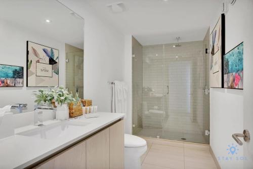 a white bathroom with a toilet and a shower at Bayview Luxury, 3BR Condo, Stunning Amenities in Hollywood