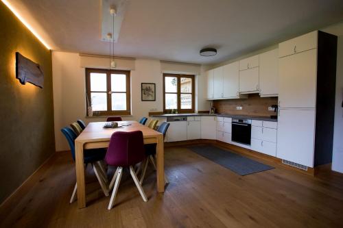 a kitchen with a table and chairs in a room at Schneckenhaus Dachstein West in Russbach am Pass Gschütt
