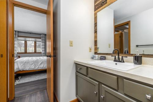 1 dormitorio y baño con lavabo y espejo. en Cozy at Creekwood Getaway en Galena