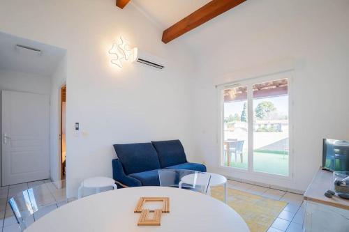 un salon avec une table et un canapé bleu dans l'établissement La Terraza, T2 avec Clim, Parking, Port Marianne, à Montpellier