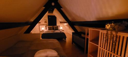 a attic room with a bed and a bed at Sea-renity 23 met sauna en jacuzzi in Eggewaartskapelle