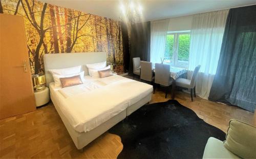 Un dormitorio con una gran cama blanca y una mesa en Gemütliches Apartment My Little Black Forest en Freiburg im Breisgau