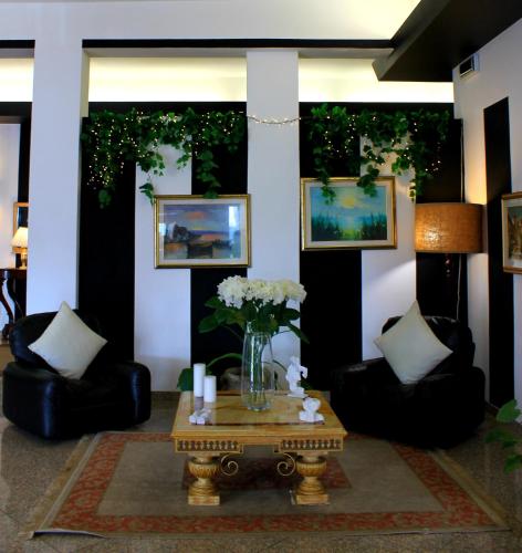 a living room with chairs and a table with flowers at Hotel Nuovo Sole HNS in Bovolone