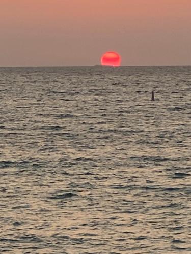un sol rojo en medio del océano en MAR AZUL ISLA BARU, RESTAURANTE HOTEL., en Playa Blanca