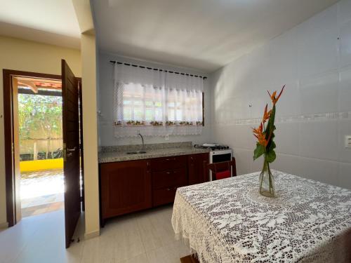 uma cozinha com uma mesa com um vaso de flores em Pousada Berro do Jeguy em Pipa