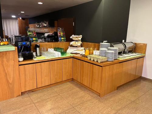 a restaurant with a counter with plates and coffeeutics at Hotel Eminent in Stupava