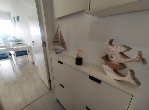 a kitchen with a dresser with two wooden seahorses on it at JES holidays in Costa da Caparica