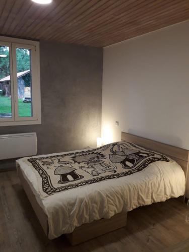 une chambre avec un lit avec une couverture dessus dans l'établissement la paisible Landaise, à Sainte-Eulalie-en-Born