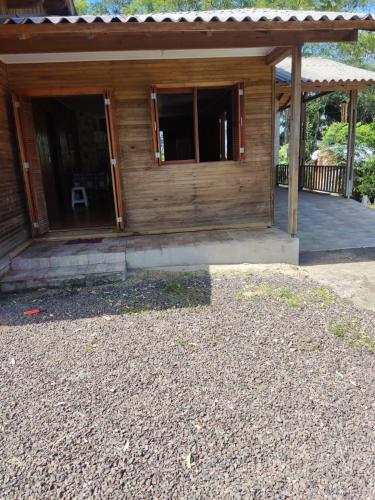 uma casa de madeira com um alpendre e um pátio em Sitio maquine em Maquiné