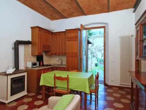 a kitchen with a table with a green table cloth at Casa Francesca in Scarlino