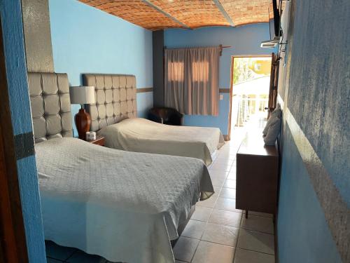 a bedroom with two beds and a door to a patio at HOTEL CUATRO CAMINOS in Etzatlán