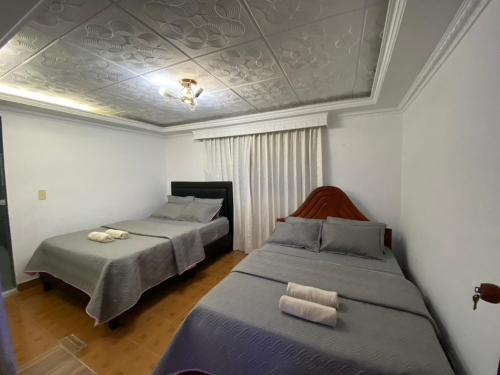 um quarto com 2 camas e um tecto em Apartaestudio la vaca em La Trinidad