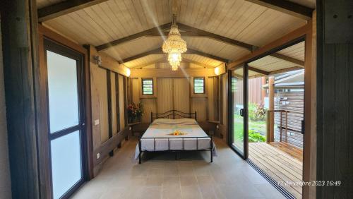 a bedroom with a bed on a porch with a chandelier at Residence Vainau Moorea in Haapiti