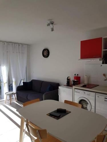 un salon avec une table blanche et un canapé dans l'établissement villa des lauriers roses, à Valras-Plage