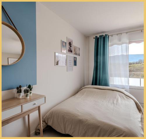 Schlafzimmer mit einem Bett und einem Tisch mit einem Spiegel in der Unterkunft Appart T2 Elegant St Julien in Saint-Julien-en-Genevois
