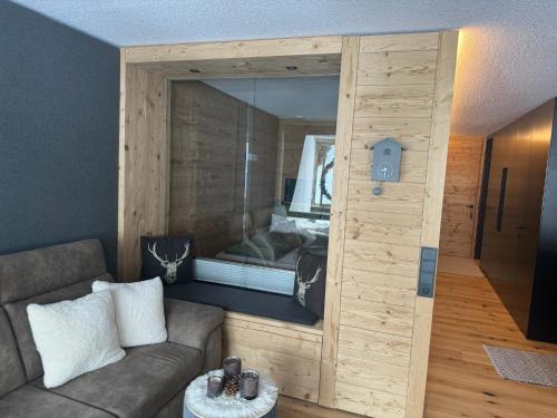 salon z kanapą i dużym lustrem w obiekcie TOP 40 w mieście Warth am Arlberg