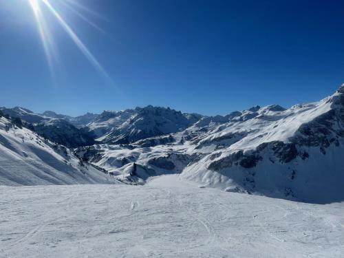 a snow covered mountain with the sun in the sky at TOP 40 Haus Sonnalp in Warth am Arlberg