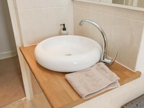 La salle de bains est pourvue d'un lavabo blanc et d'un miroir. dans l'établissement Luna Cottage, à Purmerend