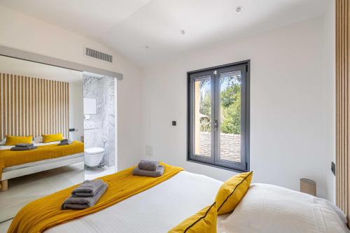 1 dormitorio con 2 camas y ventana en Modern Villa with Heated Pool and Garden, en Mougins
