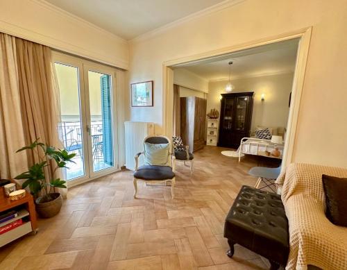 1 dormitorio y sala de estar con sofá y sillas. en Elli & Klairi Apartment, en Ágios Rókkos