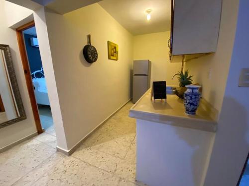 a kitchen with a counter and a refrigerator at Gloria’s Cozy Apartment in La Romana
