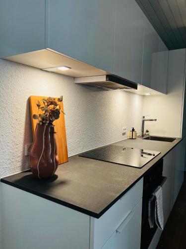 a kitchen with a vase with flowers on a counter at Cozy Flats Silkeborg - 1MTH in Silkeborg
