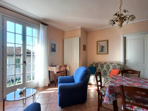 een woonkamer met een blauwe stoel en een tafel bij Appartamento Porto 2 in Cannero Riviera
