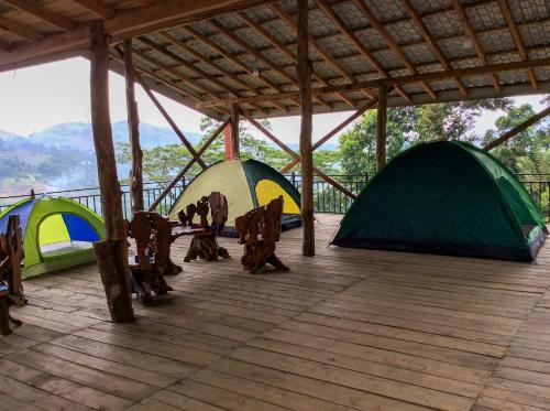 grupa namiotów siedzących na drewnianym pokładzie w obiekcie Deltota Lake View Camping w mieście Deltota