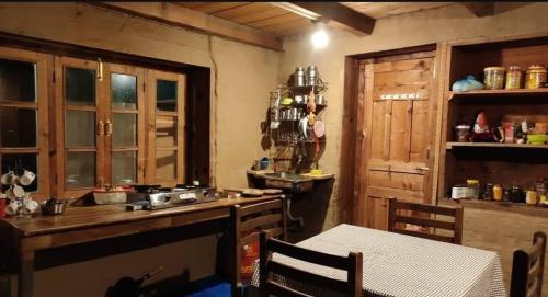 a kitchen with a counter and a table in a room at Woodside Traditional Homestays in Nagar