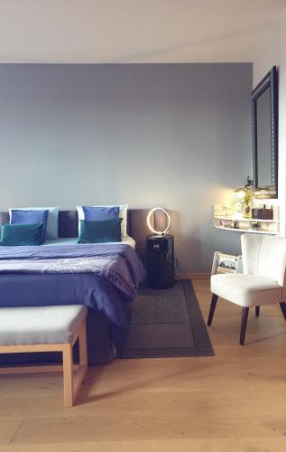 une chambre avec un grand lit et une chaise dans l'établissement Studio Non Fumeur 38m2 calme, confort, ascenseur, à Béziers