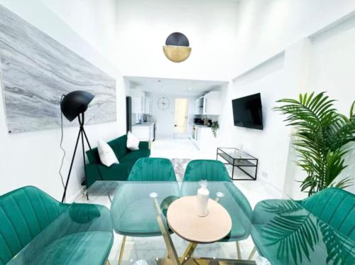 sala de estar con sillas verdes y mesa en Modern Luxury 2 Bed with Parking, en Catford
