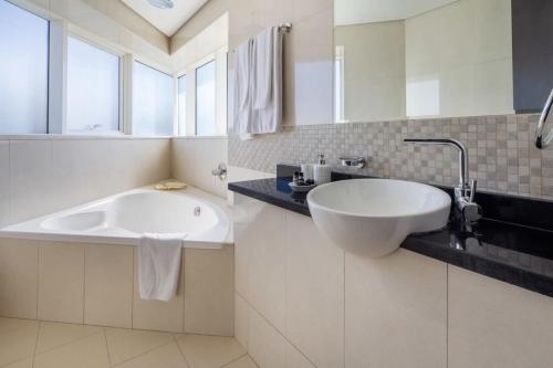 a white bathroom with a sink and a mirror at Frank Porter - The Bridge in Dubai