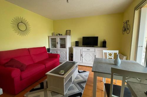 un salon avec un canapé rouge et une table dans l'établissement Cozy love cocoon with balcony and pool, à Sainte-Maxime