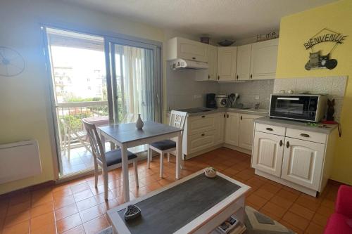 une petite cuisine avec une table et un micro-ondes dans l'établissement Cozy love cocoon with balcony and pool, à Sainte-Maxime