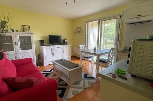 un salon avec un canapé rouge et une table dans l'établissement Cozy love cocoon with balcony and pool, à Sainte-Maxime