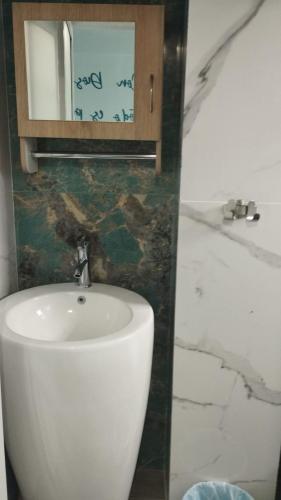a bathroom with a white sink and a mirror at HOTEL DE LOS COLORES in El Queremal
