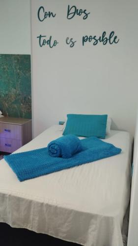 a bed with a blue towel on top of it at HOTEL DE LOS COLORES in El Queremal