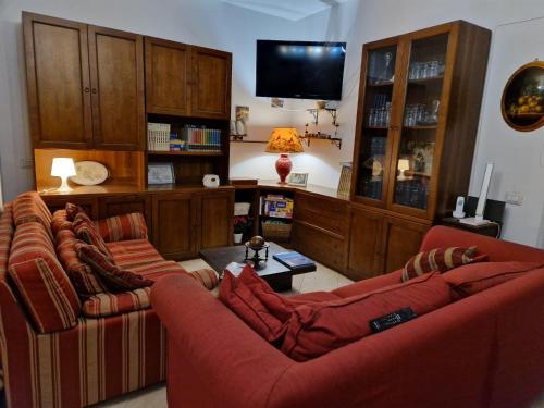 ein Wohnzimmer mit 2 Sofas und einem Flachbild-TV in der Unterkunft Il Focolare in Focene