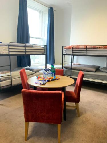 Cette chambre comprend une table, des chaises et des lits superposés. dans l'établissement Tara Suite Private Room, à Dublin
