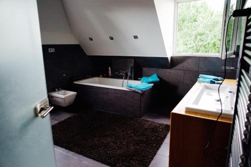 ein Badezimmer mit einer Badewanne und einem Waschbecken in der Unterkunft Ferienhaus Celeste in Warnemünde