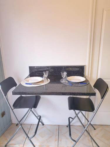a table with chairs and plates and glasses on it at Maison hyper calme proche RER, à 2 arrêts du Stade de France, 25min Paris centre, proche, Disney, Astérix, CDG in Stains