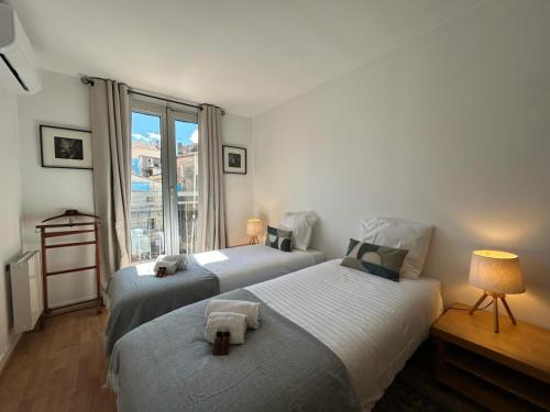 deux lits dans une chambre avec une fenêtre dans l'établissement 3 PIECES EN DUPLEX - calme proche Croisette A2B234, à Cannes