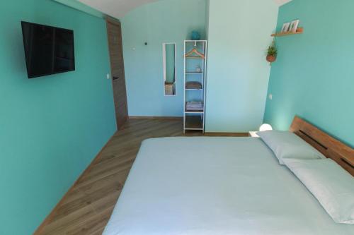 a bedroom with a large white bed and a television at B&B Casa V-Ale in Collegno