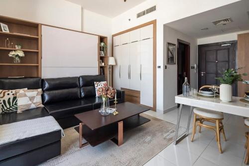 a living room with a black leather couch and a table at Frank Porter - Starz by Danube in Dubai