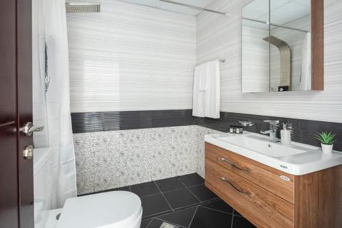 a bathroom with a sink and a toilet and a tub at Frank Porter - Starz by Danube in Dubai