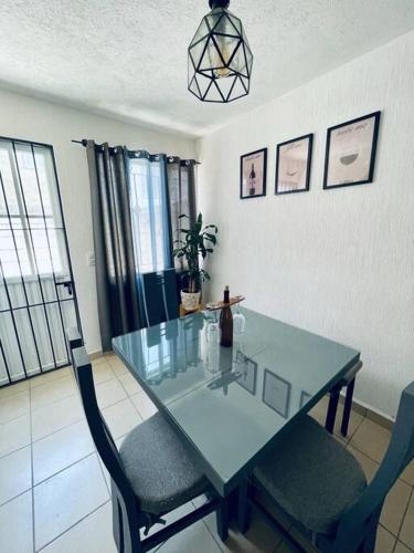 a dining room with a glass table and two chairs at Casa Azul in San Miguel in San Miguel de Allende
